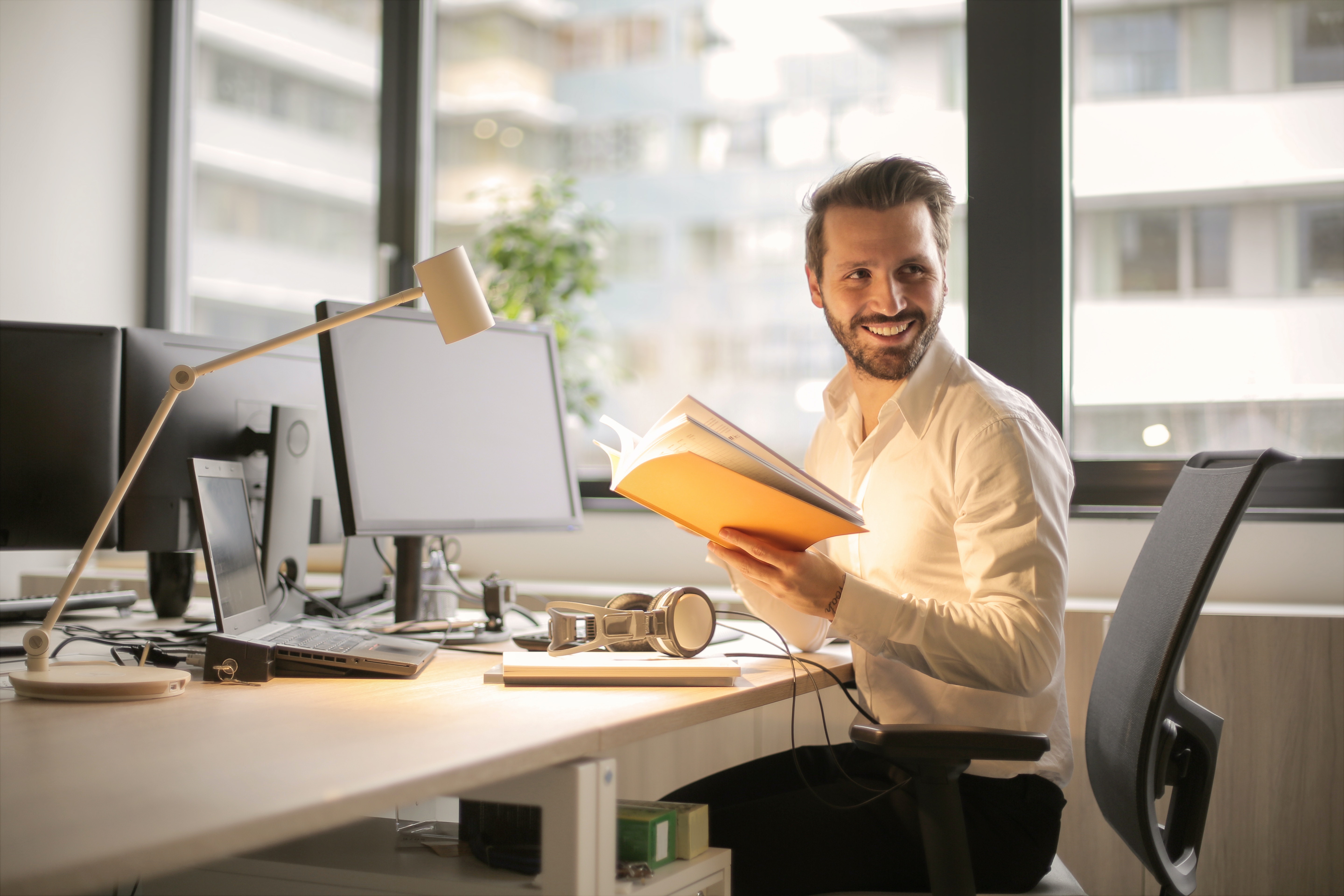 Man holding a book smiling, learning how to attract candidates